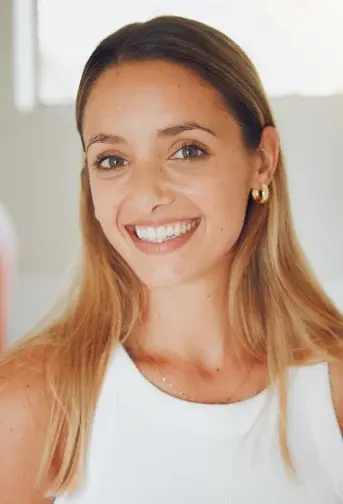 Smiling woman with healthy teeth in white top at Cedar City dental practice.