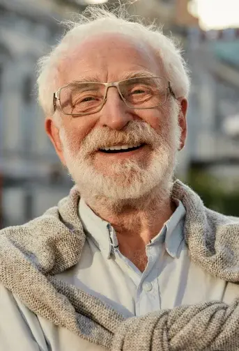 Smiling senior man with glasses wearing a cardigan in Cedar City.